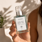 Hand holding a bottle of Blue Tansy Body Oil with a blurred background