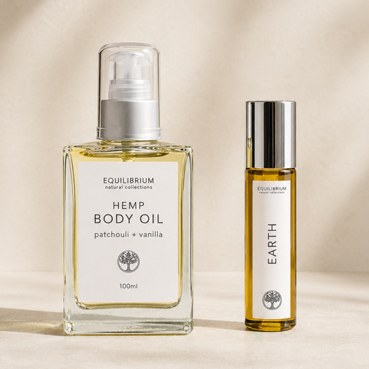 bottle of Equilibrium hemp body oil with matching patchouli and vanilla perfume on a beige background