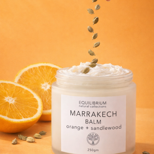 Marrakech Balm jar with oranges and seeds on an orange background